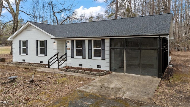 view of front facade featuring crawl space, a shingled roof, and brick siding