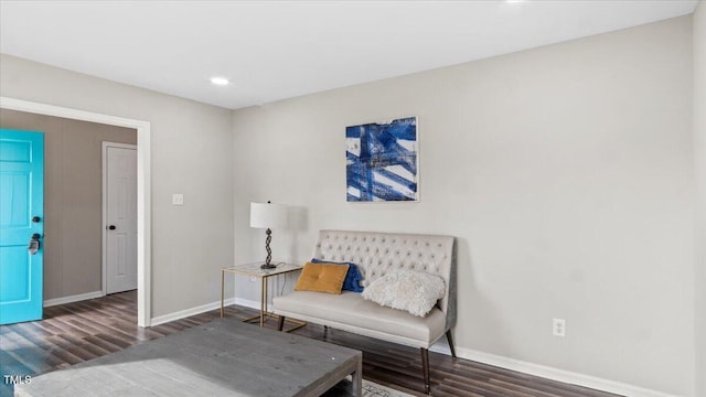 living area featuring dark wood-style flooring and baseboards