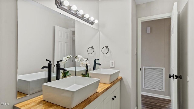 full bathroom featuring visible vents, a sink, and double vanity