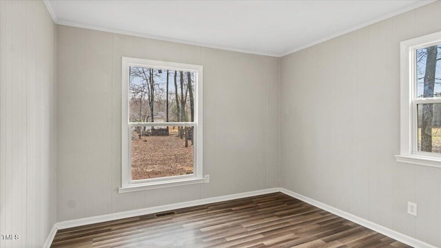 empty room featuring baseboards, visible vents, and dark wood-type flooring