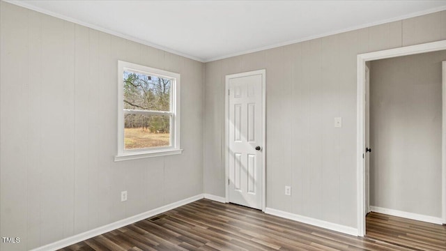 unfurnished bedroom featuring baseboards and dark wood-style flooring