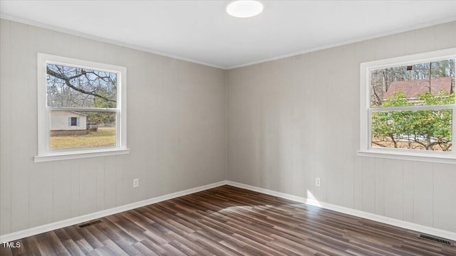 unfurnished room featuring dark wood-type flooring, visible vents, and plenty of natural light