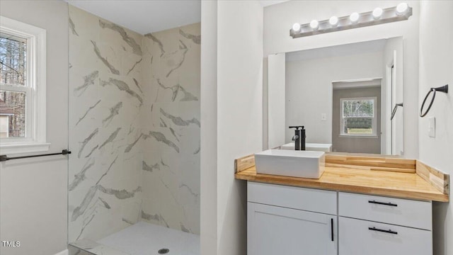 full bath with vanity and a marble finish shower