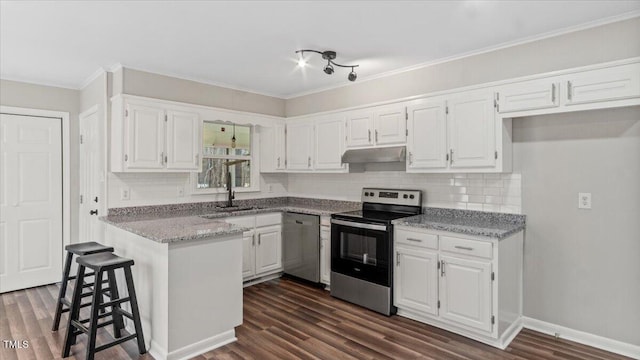 kitchen featuring under cabinet range hood, stainless steel appliances, a kitchen breakfast bar, white cabinets, and dark wood finished floors