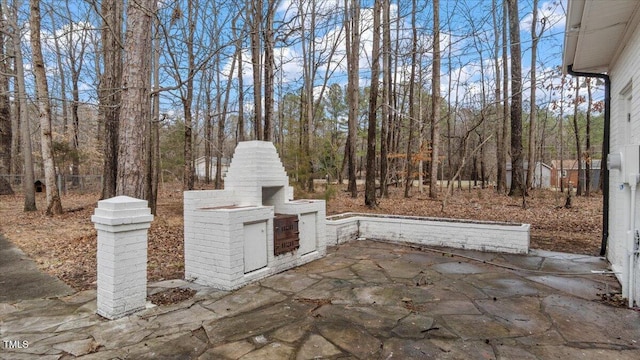 view of patio with an outdoor brick fireplace