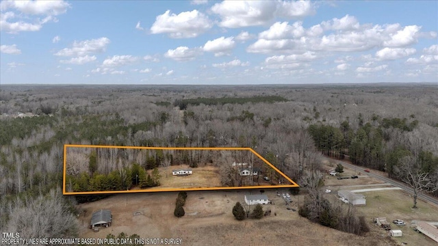 drone / aerial view with a wooded view