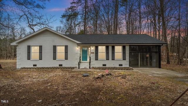 view of front of house with entry steps, brick siding, driveway, crawl space, and roof with shingles