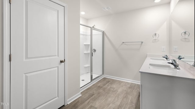 bathroom featuring hardwood / wood-style flooring, vanity, and a shower with door