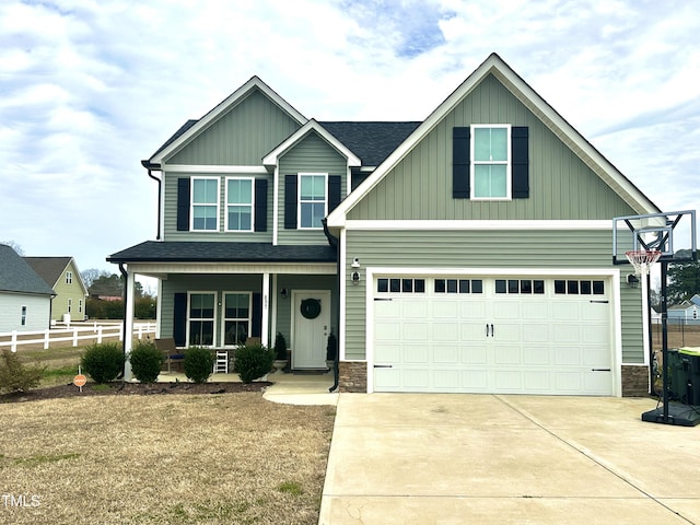 craftsman inspired home featuring stone siding, a porch, concrete driveway, and fence