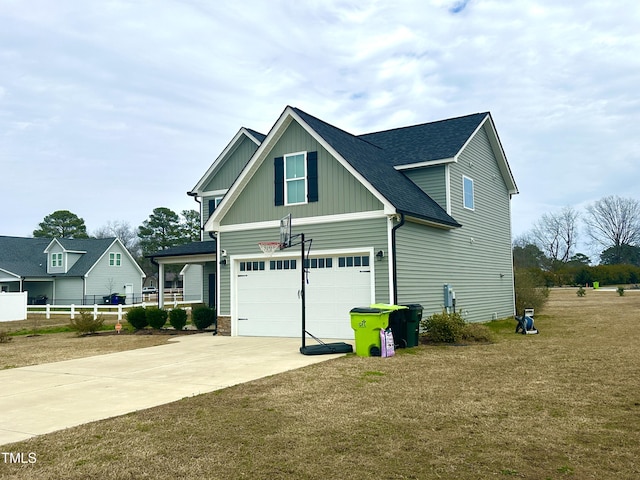 view of side of home featuring concrete driveway, a yard, board and batten siding, and a shingled roof