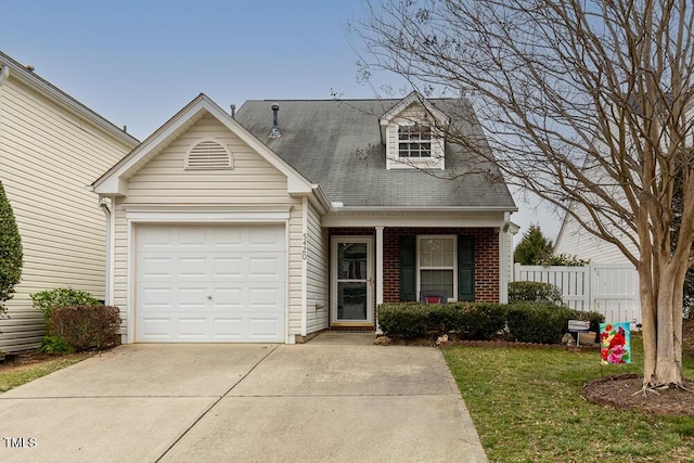 new england style home with brick siding, an attached garage, a front yard, fence, and driveway