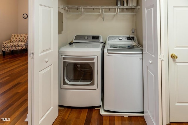 washroom featuring laundry area, dark wood-type flooring, and washing machine and clothes dryer