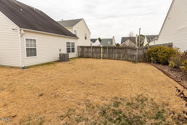 view of yard with a fenced backyard and central AC