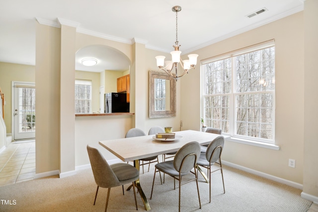 dining area with visible vents, plenty of natural light, light carpet, and baseboards