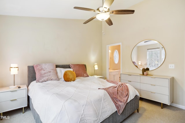 bedroom featuring light colored carpet, connected bathroom, baseboards, and ceiling fan