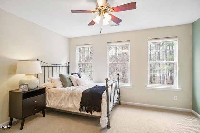 bedroom with light carpet, multiple windows, visible vents, and baseboards