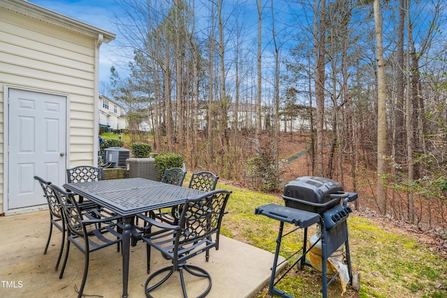 view of patio / terrace featuring outdoor dining space, grilling area, and central AC unit