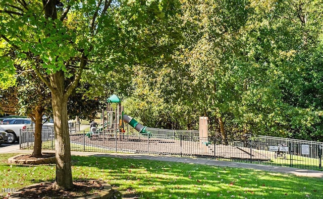 community jungle gym featuring fence and a lawn