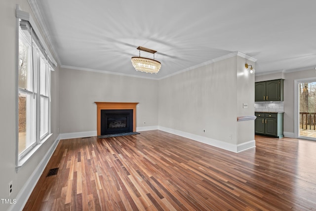 unfurnished living room featuring dark wood-style floors, a fireplace, visible vents, and ornamental molding