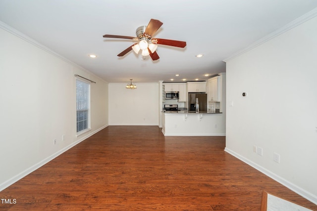 unfurnished living room with recessed lighting, dark wood-type flooring, ornamental molding, baseboards, and ceiling fan with notable chandelier