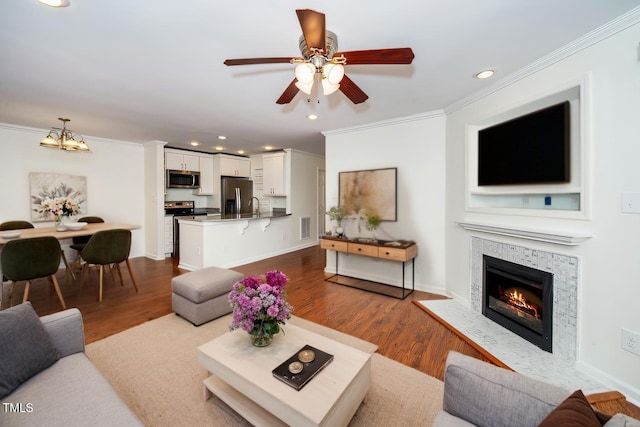 living room featuring ornamental molding, baseboards, visible vents, and light wood finished floors