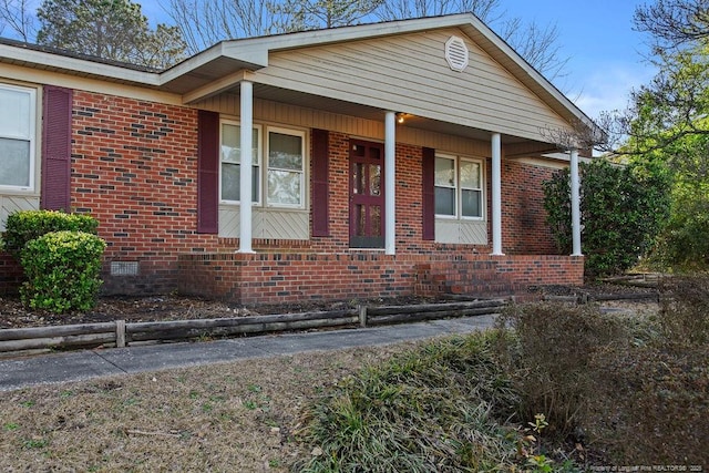 bungalow-style house featuring brick siding and crawl space