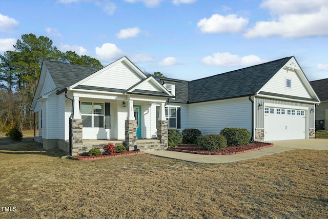 view of front of home featuring a porch, an attached garage, stone siding, concrete driveway, and a front yard