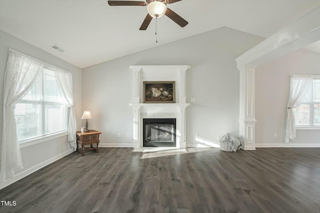 unfurnished living room featuring lofted ceiling, dark wood-type flooring, a fireplace with flush hearth, and visible vents