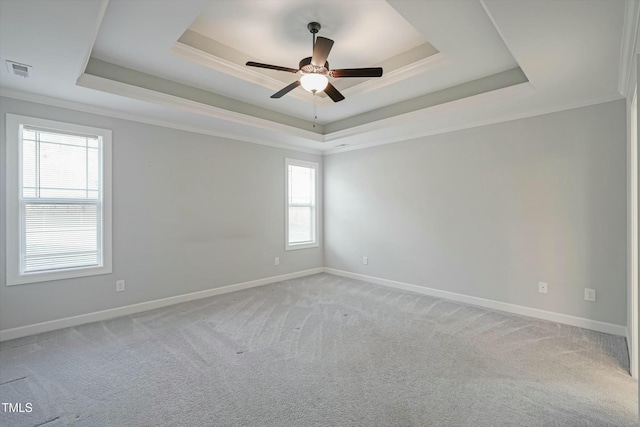 unfurnished room with light carpet, visible vents, a raised ceiling, and crown molding