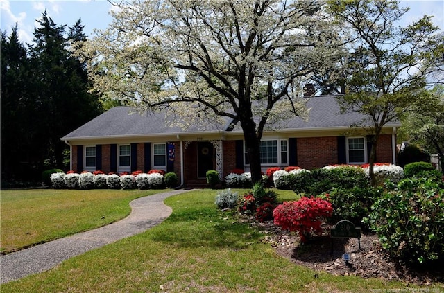 ranch-style house with a front lawn and brick siding