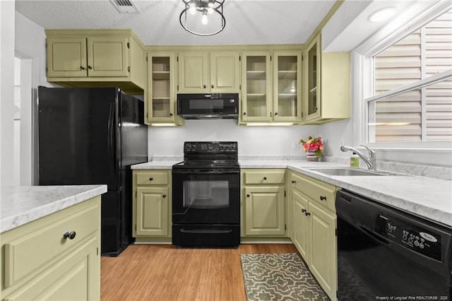 kitchen with light hardwood / wood-style flooring, sink, a textured ceiling, and black appliances