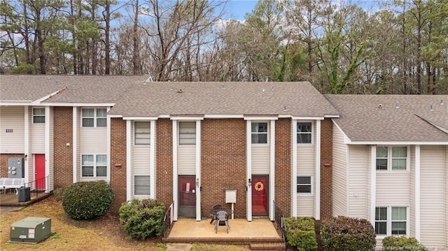 townhome / multi-family property with a front yard and a patio area