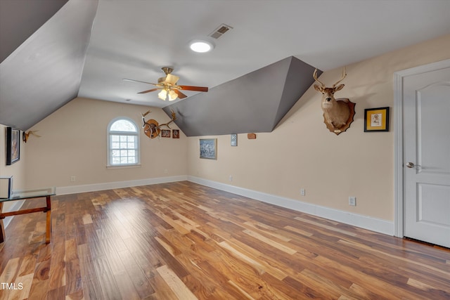 additional living space with ceiling fan, baseboards, vaulted ceiling, and wood finished floors