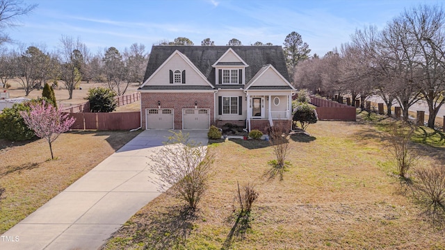 traditional-style home featuring brick siding, concrete driveway, fence, a garage, and a front lawn