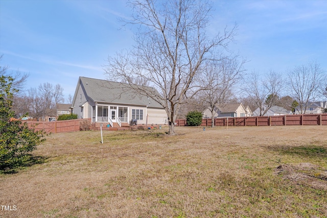 view of yard with a garage and a fenced backyard