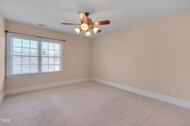 empty room with visible vents, light carpet, and baseboards