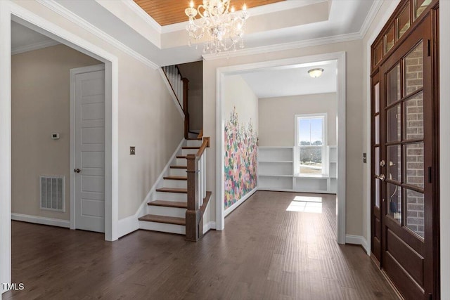 entrance foyer featuring visible vents, dark wood-style flooring, and a tray ceiling