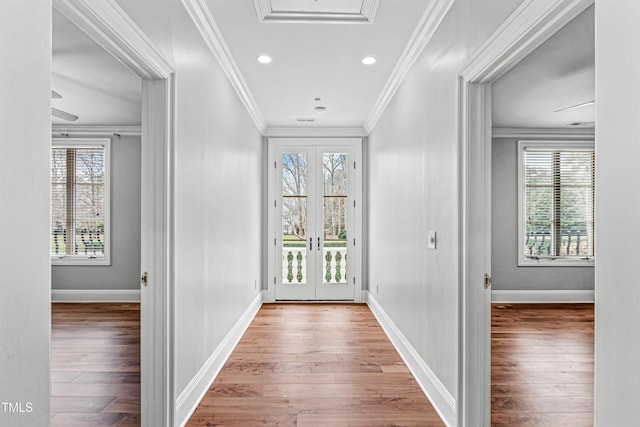 hallway featuring french doors, a wealth of natural light, and ornamental molding