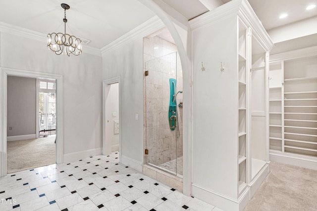 bathroom featuring a shower stall, a walk in closet, baseboards, ornamental molding, and an inviting chandelier