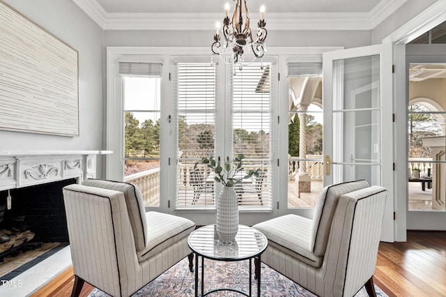 interior space featuring a healthy amount of sunlight, a fireplace, crown molding, and wood finished floors