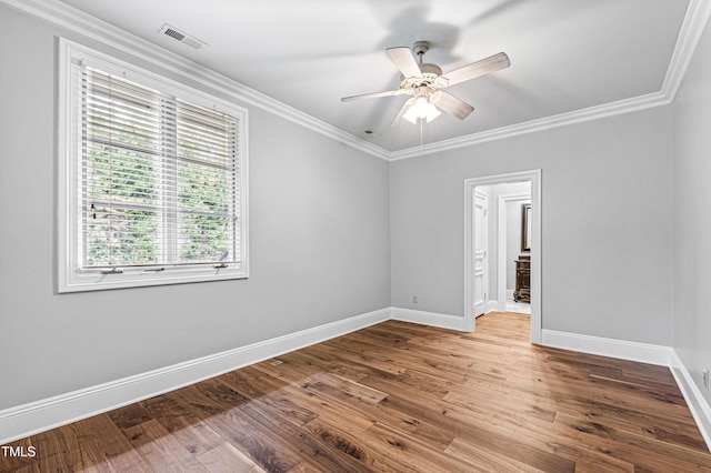 unfurnished room with wood finished floors, baseboards, and ornamental molding