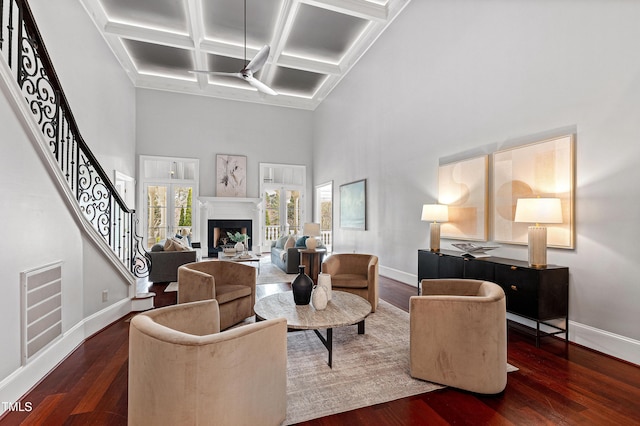 living room featuring stairway, a fireplace, baseboards, and wood finished floors