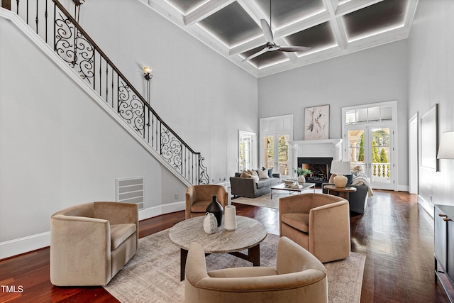 living area with stairs, wood finished floors, and a fireplace