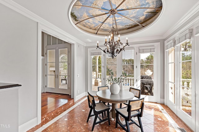 dining space featuring crown molding, baseboards, french doors, a notable chandelier, and a raised ceiling