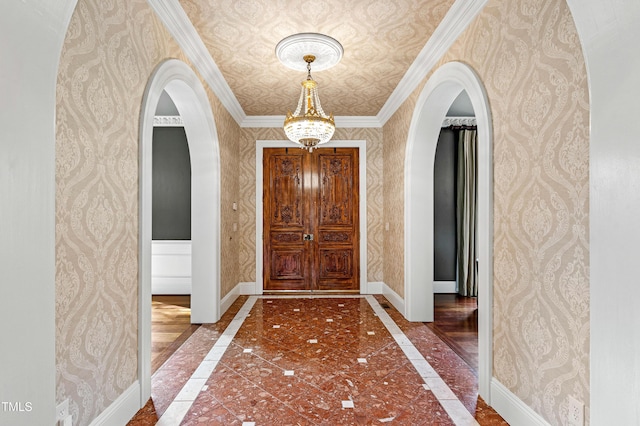 entryway with arched walkways, wallpapered walls, and baseboards