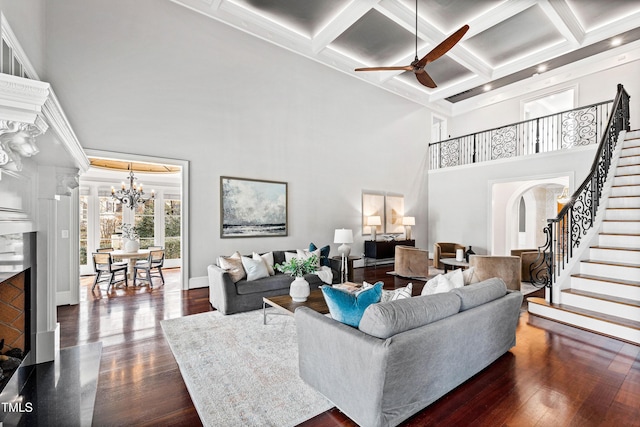 living room featuring dark wood finished floors, stairway, and a high ceiling