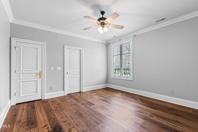 unfurnished bedroom featuring visible vents, crown molding, baseboards, and wood finished floors