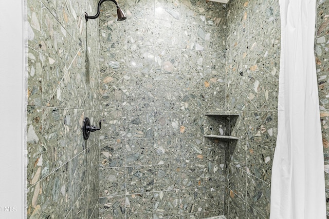 interior details featuring a tile shower