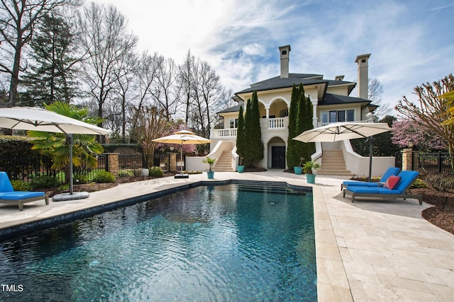 view of pool featuring a patio area, stairway, a fenced in pool, and fence