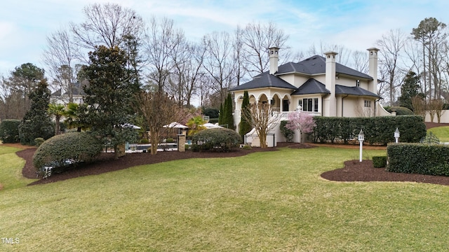 exterior space featuring stucco siding and a front lawn